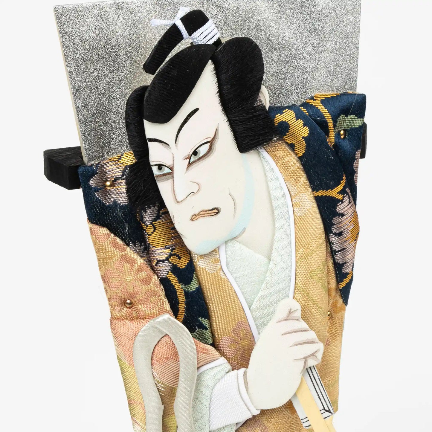 A close-up of the kabuki actor's face and upper body, highlighting the textured fabrics and expressive facial details.