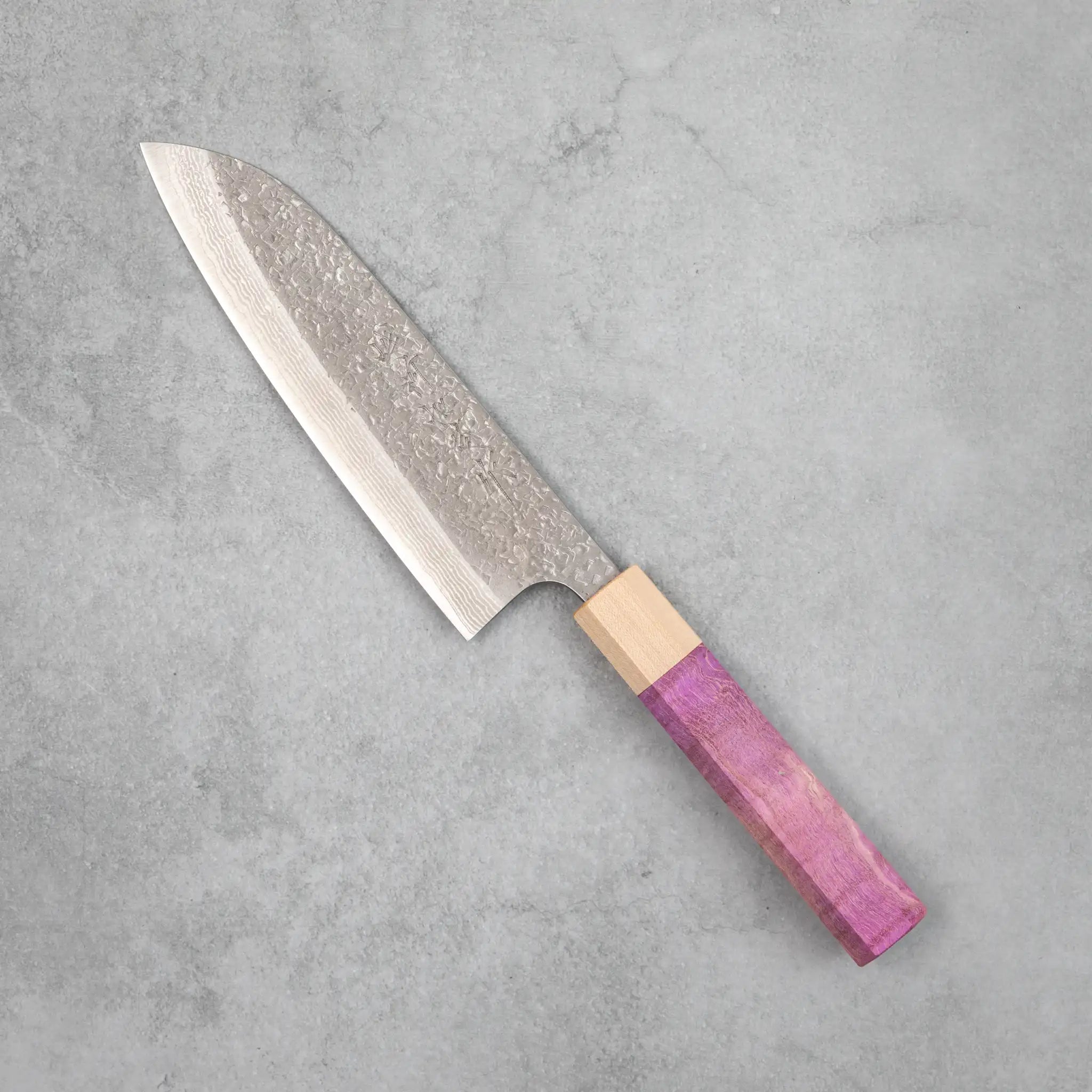 Side view of the Kamo Hamono Juhyo santoku knife with purple stabilized figured maple handle, pale maple bolster, and a VG10 Damascus blade with hammered tsuchime finish across the upper surface.
