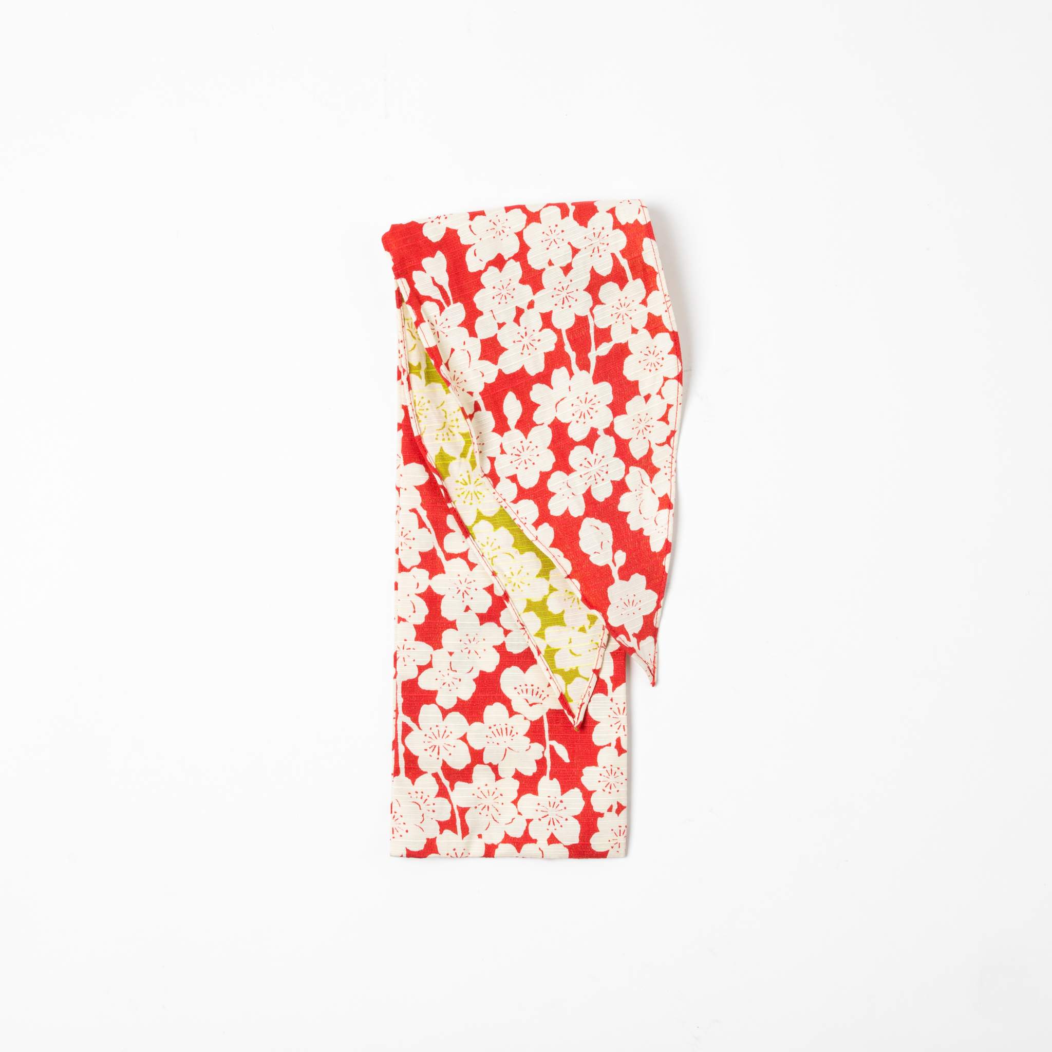 A folded Isa Moyō Folding Umbrella pouch displaying the Sakura (Cherry Blossom) motif in pink with a contrasting light green inner lining.