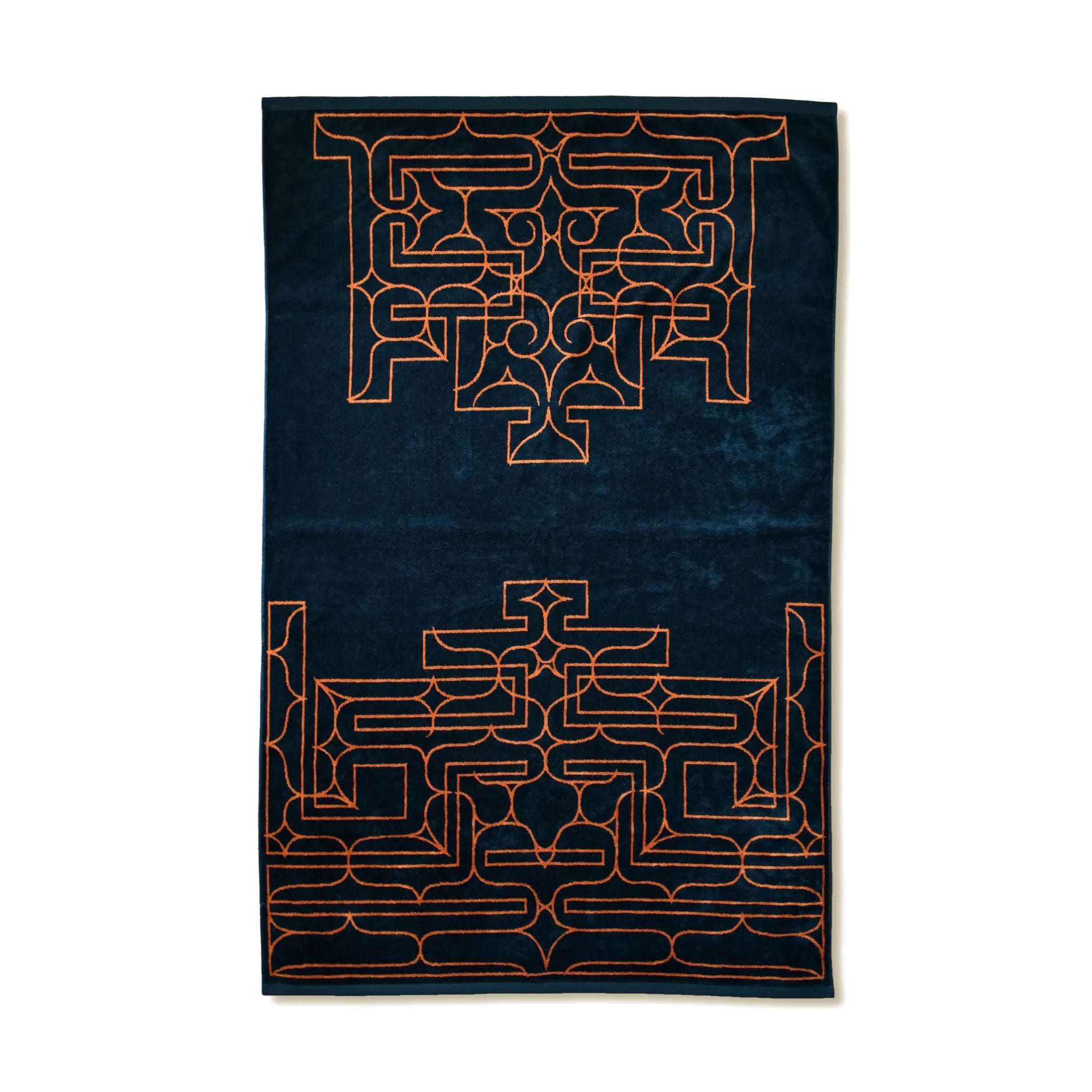 Navy blue towel with orange geometric Ainu patterns on a white background