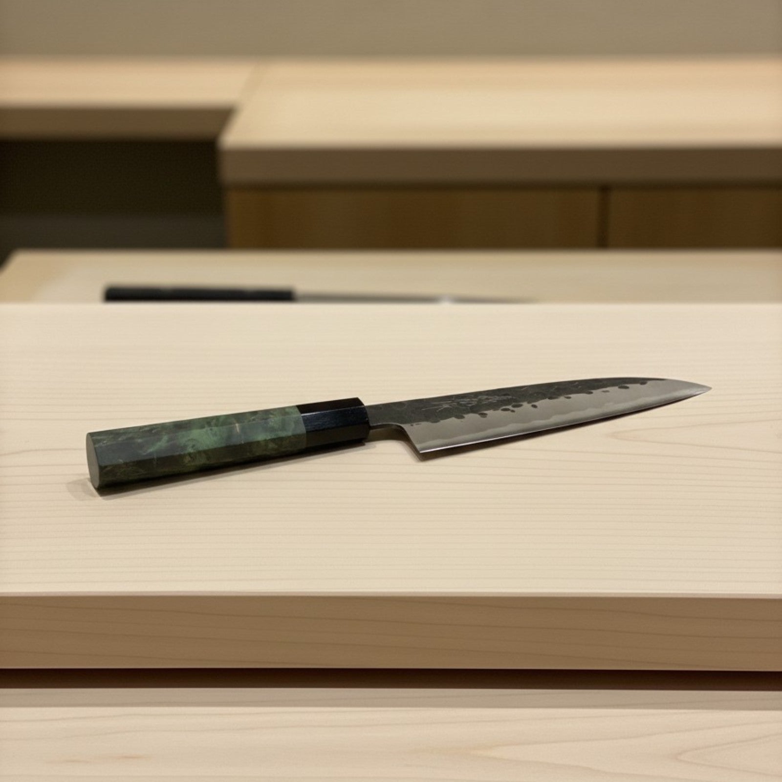 Knife with a green handle on a light wooden surface