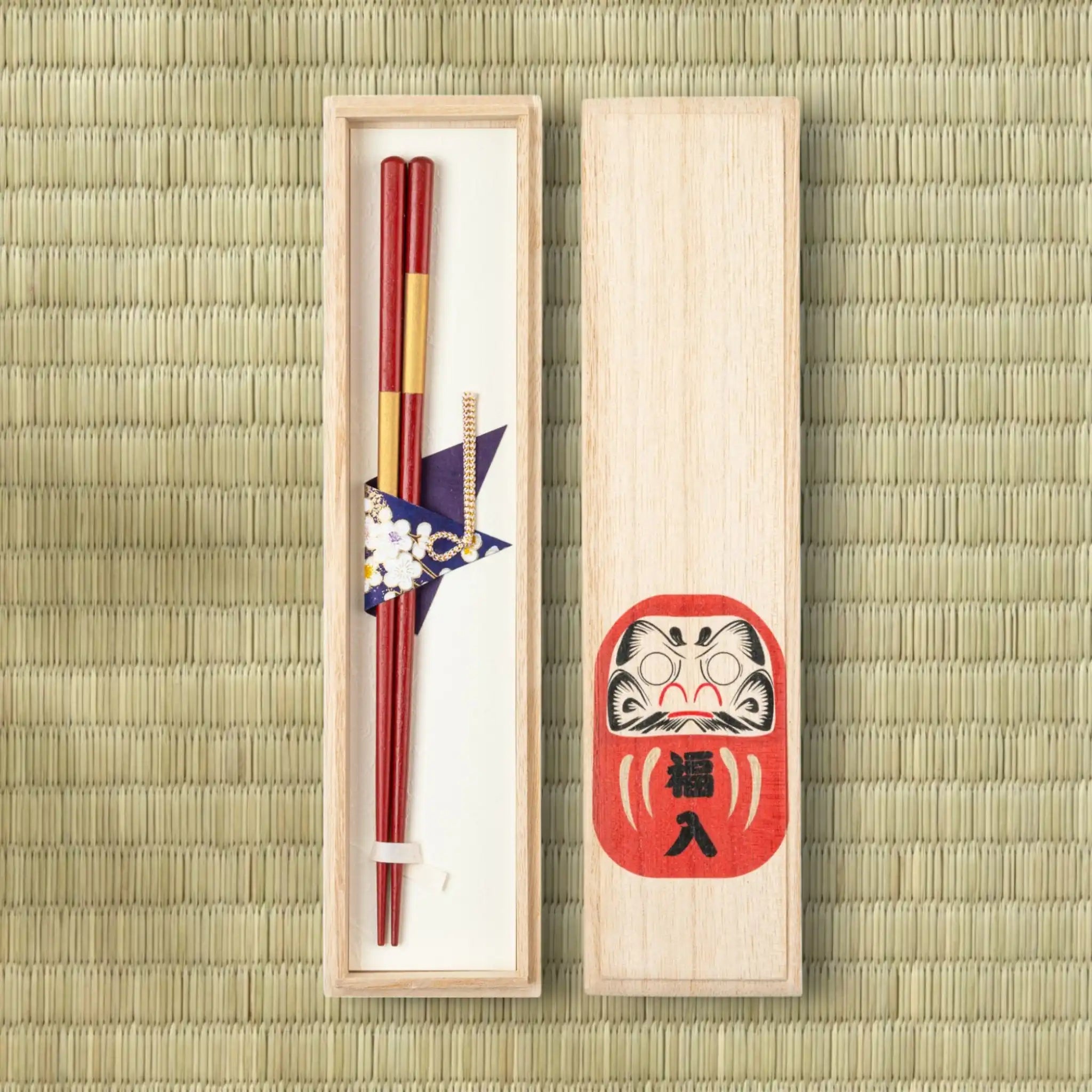 Japanese red and gold chopsticks in the gift box with the lid placed to the next