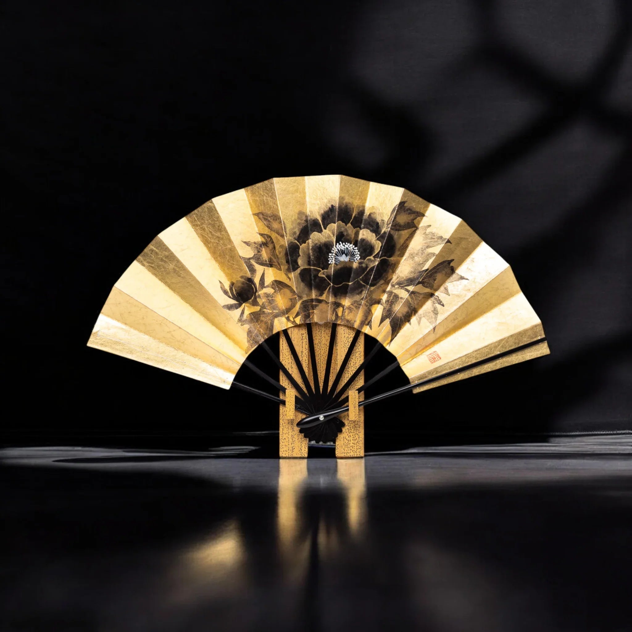 Gold japanese folding fan with black backgound