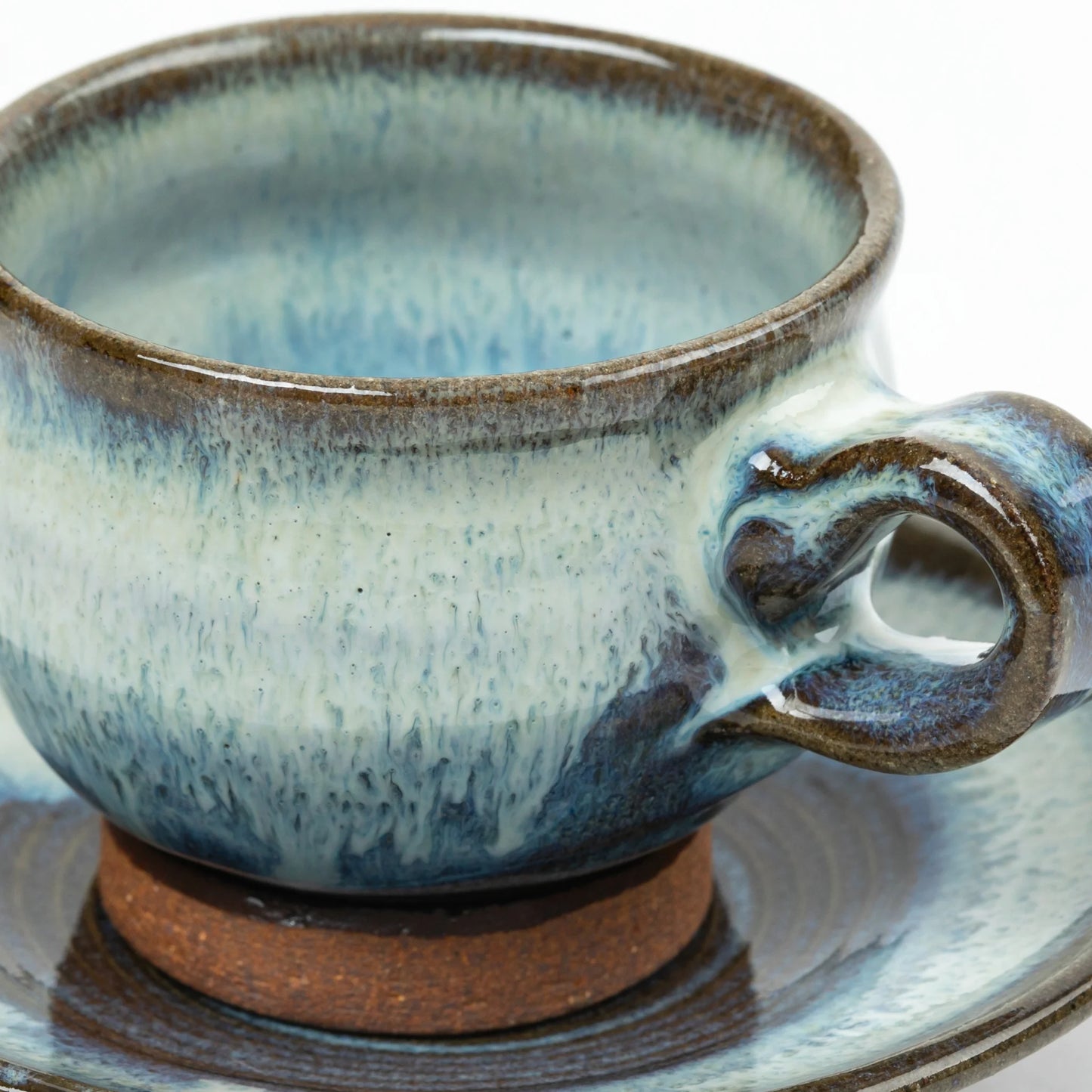 Close-up of the ceramic cup's handle and glaze texture, highlighting the rich blue gradient and artisan craftsmanship.