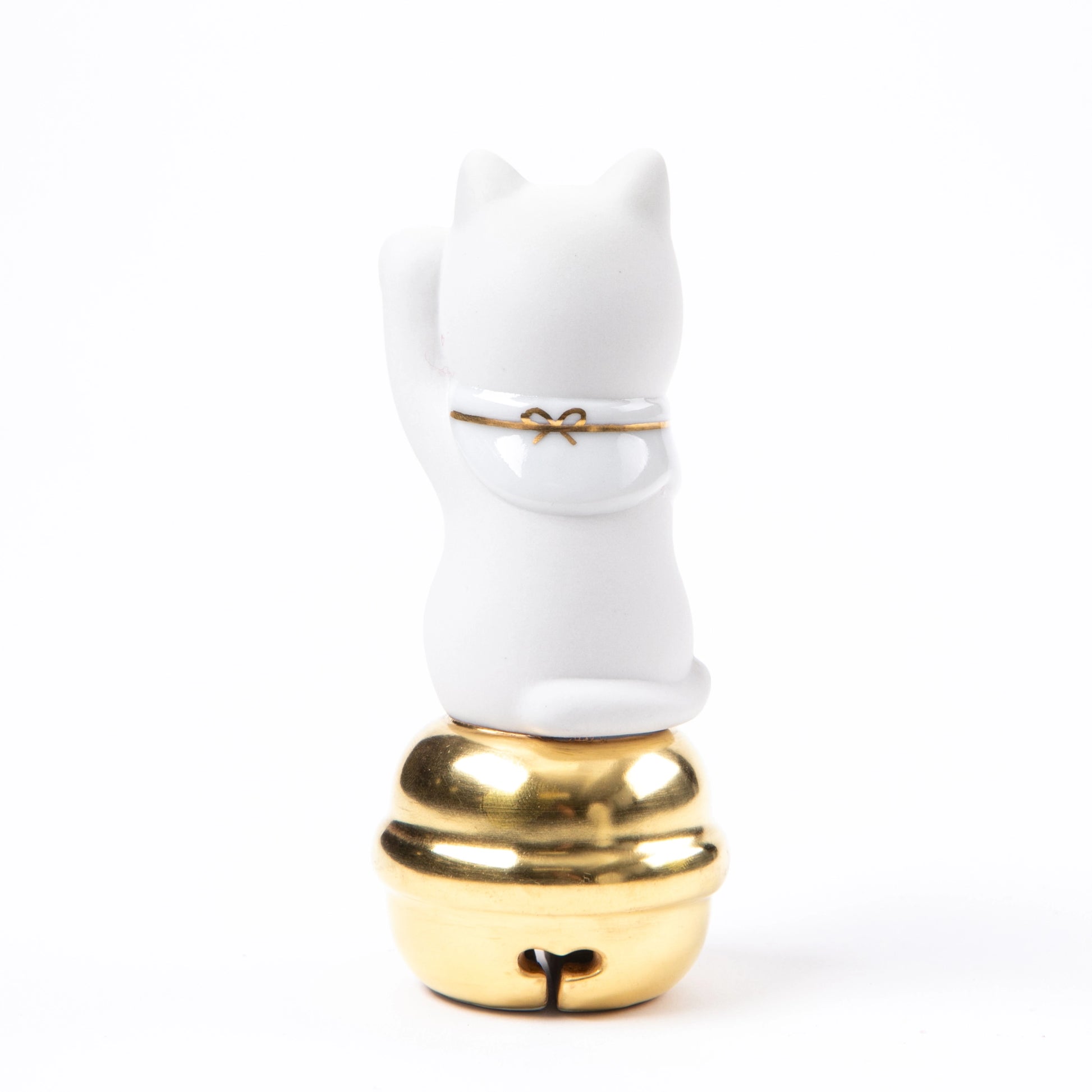 The back of the Maneki Neko figurine, showcasing a simple, elegant design with a tied ribbon on its collar and the gold-accented bell.