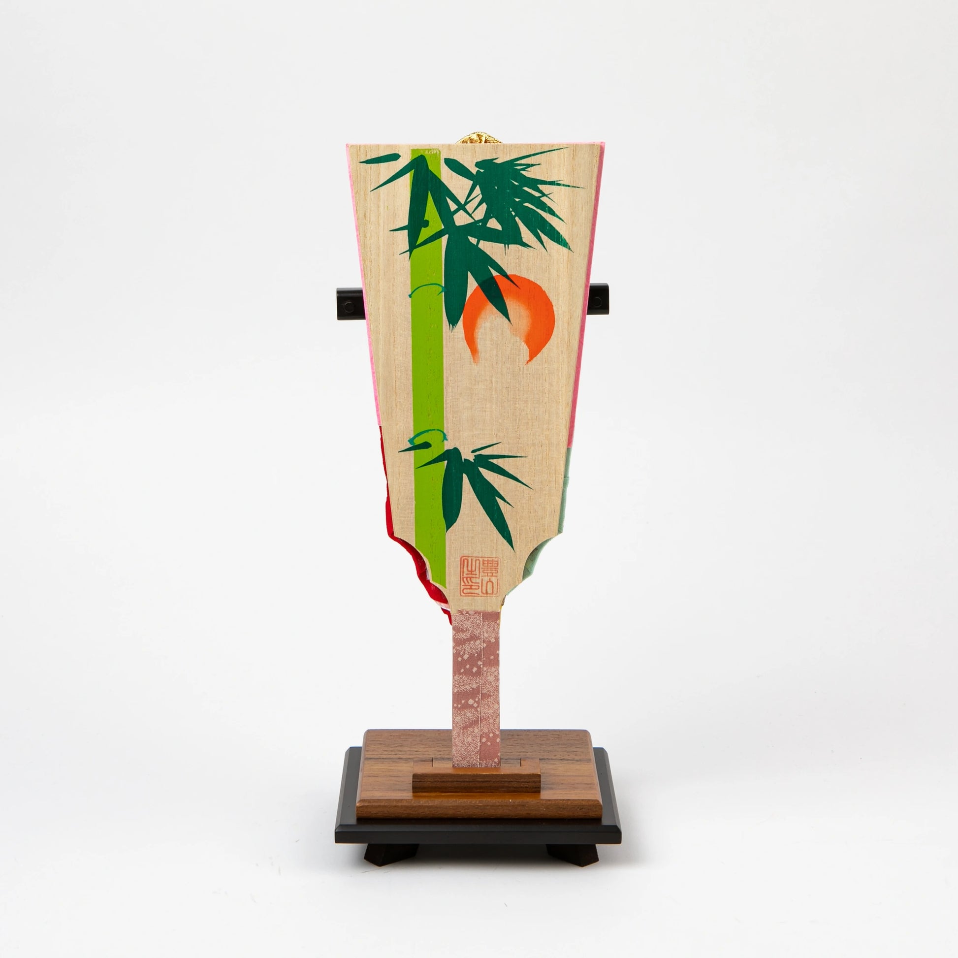 Back of the hagoita paddle with painted bamboo and orange sun design.
