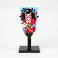 A Kabuki-inspired decorative paddle featuring a bold red costume, dramatic kumadori face paint, and intricate detailing, standing upright on a black lacquered base.