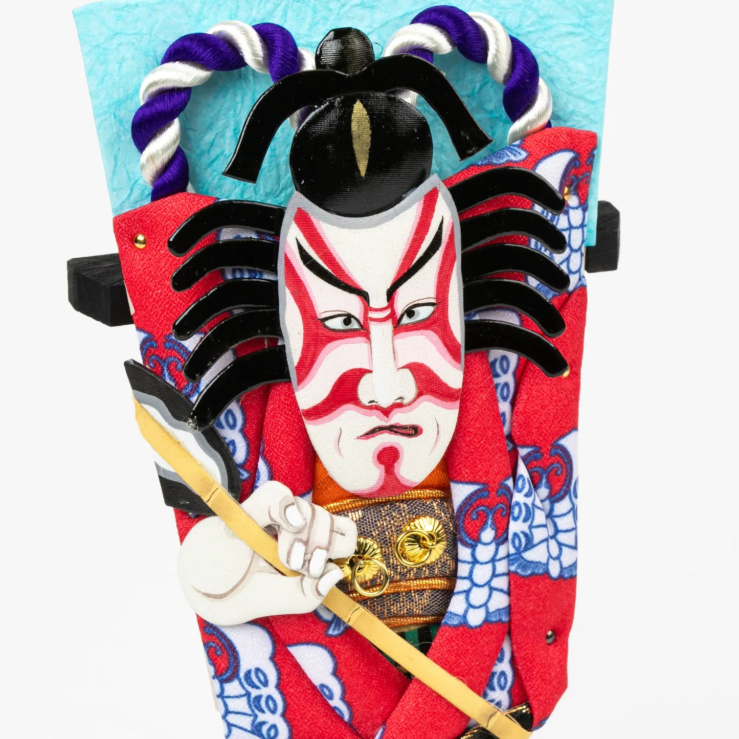 Detailed view of the intense facial expression, red and white face paint, and textured costume fabrics including gold accents and blue patterns.
