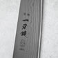 A close-up of the engraved logo and Japanese characters on the Damascus steel blade, emphasizing its craftsmanship and origin from Tsubame, Japan.