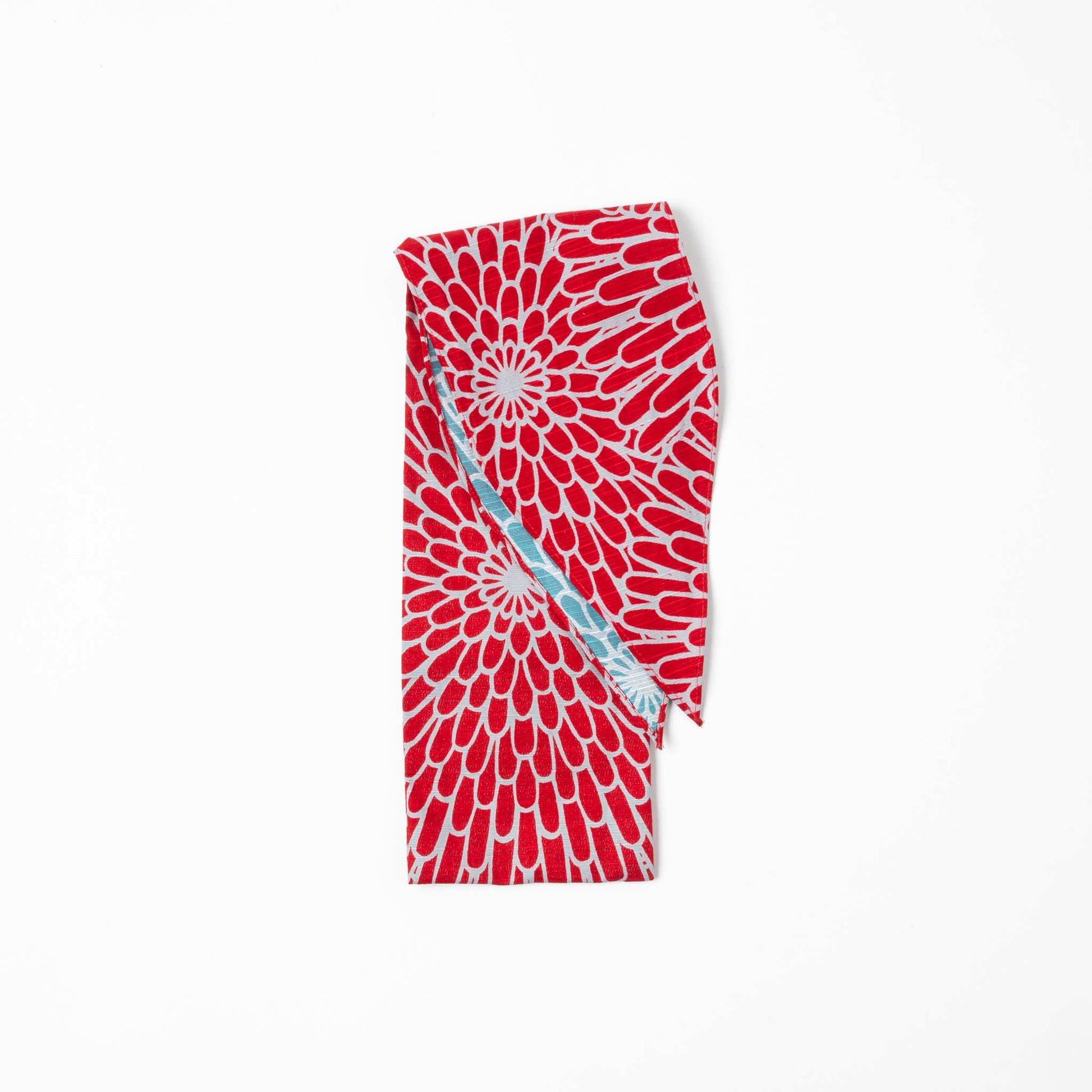 A folded Isa Moyō Folding Umbrella pouch displaying the Chrysanthemum motif in vibrant red with an inner lining of contrasting light blue.