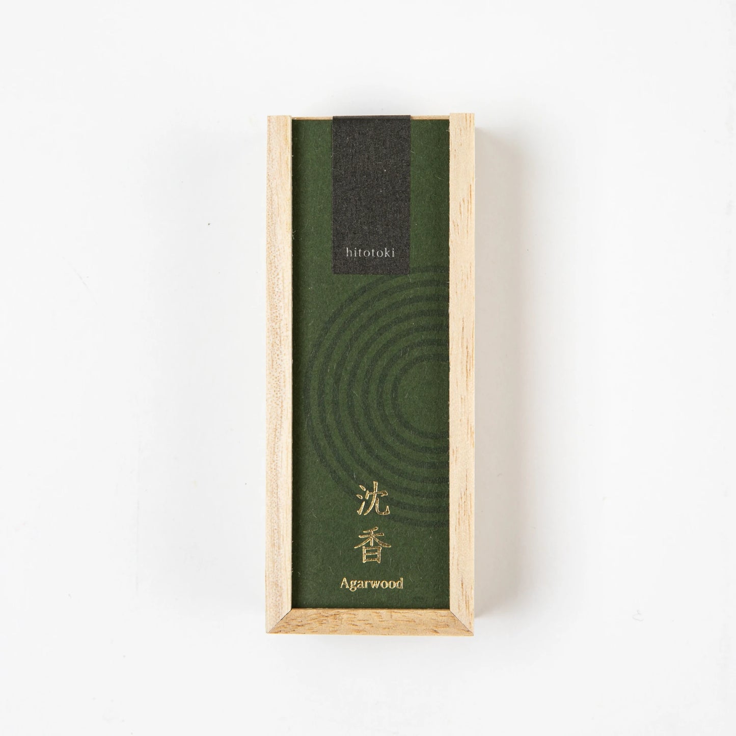 A top-down view of a rectangular wooden box with a green label reading "hitotoki Agarwood" in English and Japanese.