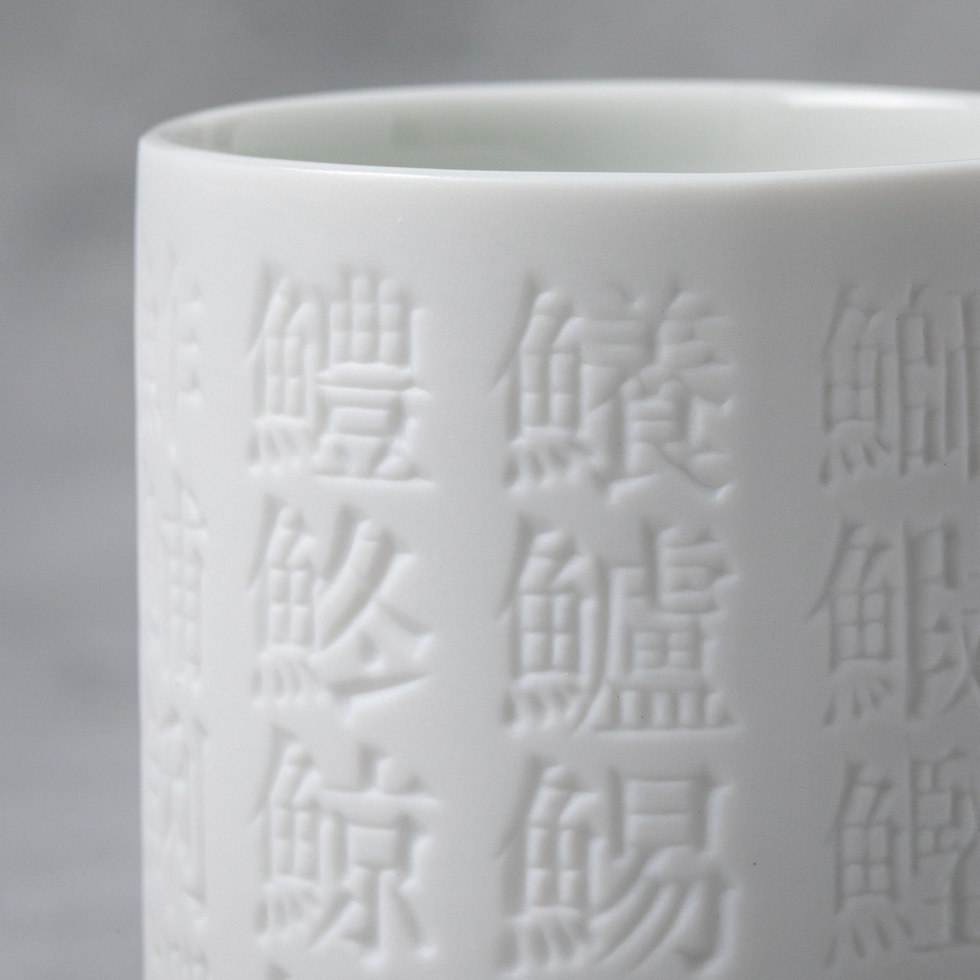 Close up of white Sushi Kanji engraved Teacup from M.M. Yoshihashi