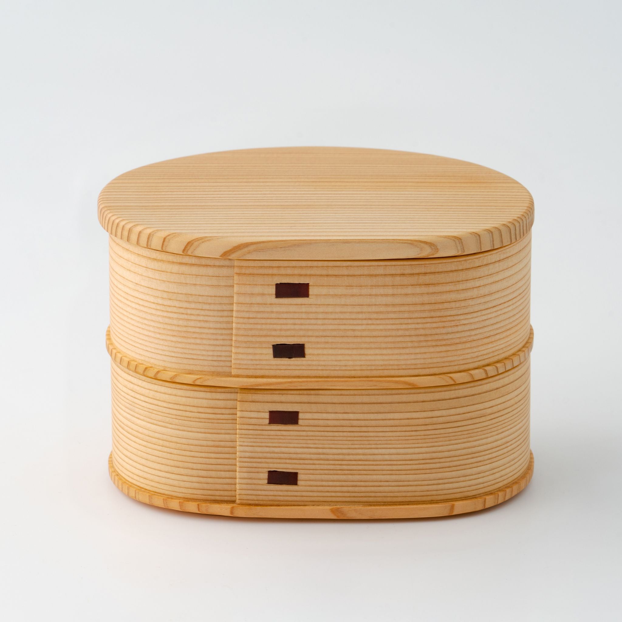A small two-tiered wooden bento box with the lid on, highlighting its minimalist design.