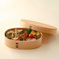A two-tiered wooden bento box with the lid on, showcasing its simple, elegant design.