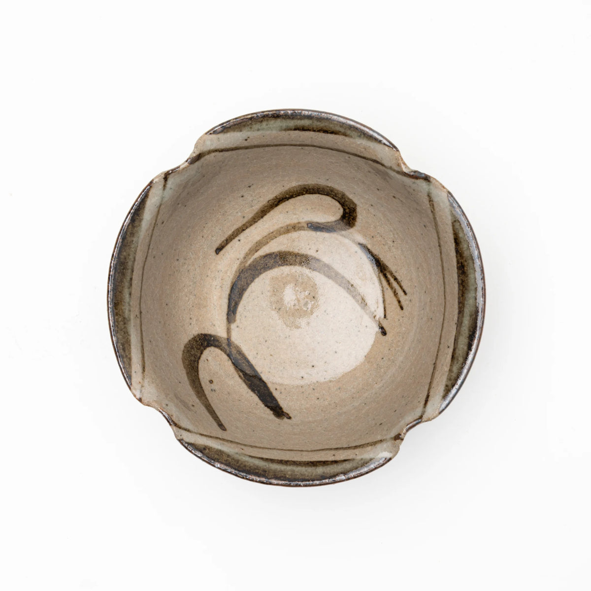 Top view of the Nakazato Tarouemon E-Karatsu susuki mukozuke serving dish, showing a rounded form with a 4-point lobed rim, pale coarse stoneware ground, and sweeping iron-oxide brushwork of pampas grass stems across the interior.