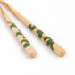 Close-up of natural wood chopsticks with a green pine tree motif, delicately hand-painted to represent the natural beauty of pine trees.