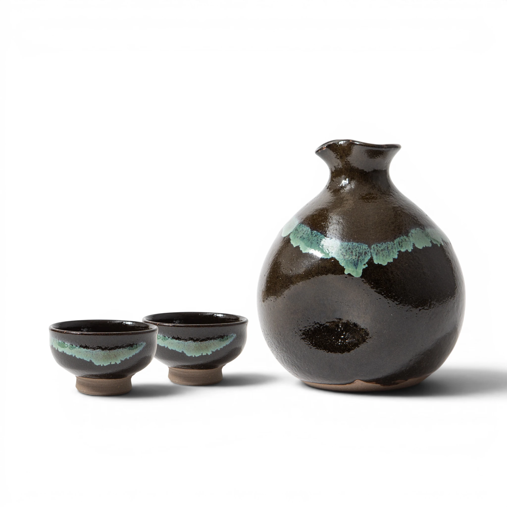 Front view of a Ryumonji Yaki black glaze sake set, showing a rounded tokkuri with a teal glaze band across the shoulder alongside 2 guinomi with the same teal band across the body and unglazed clay feet.