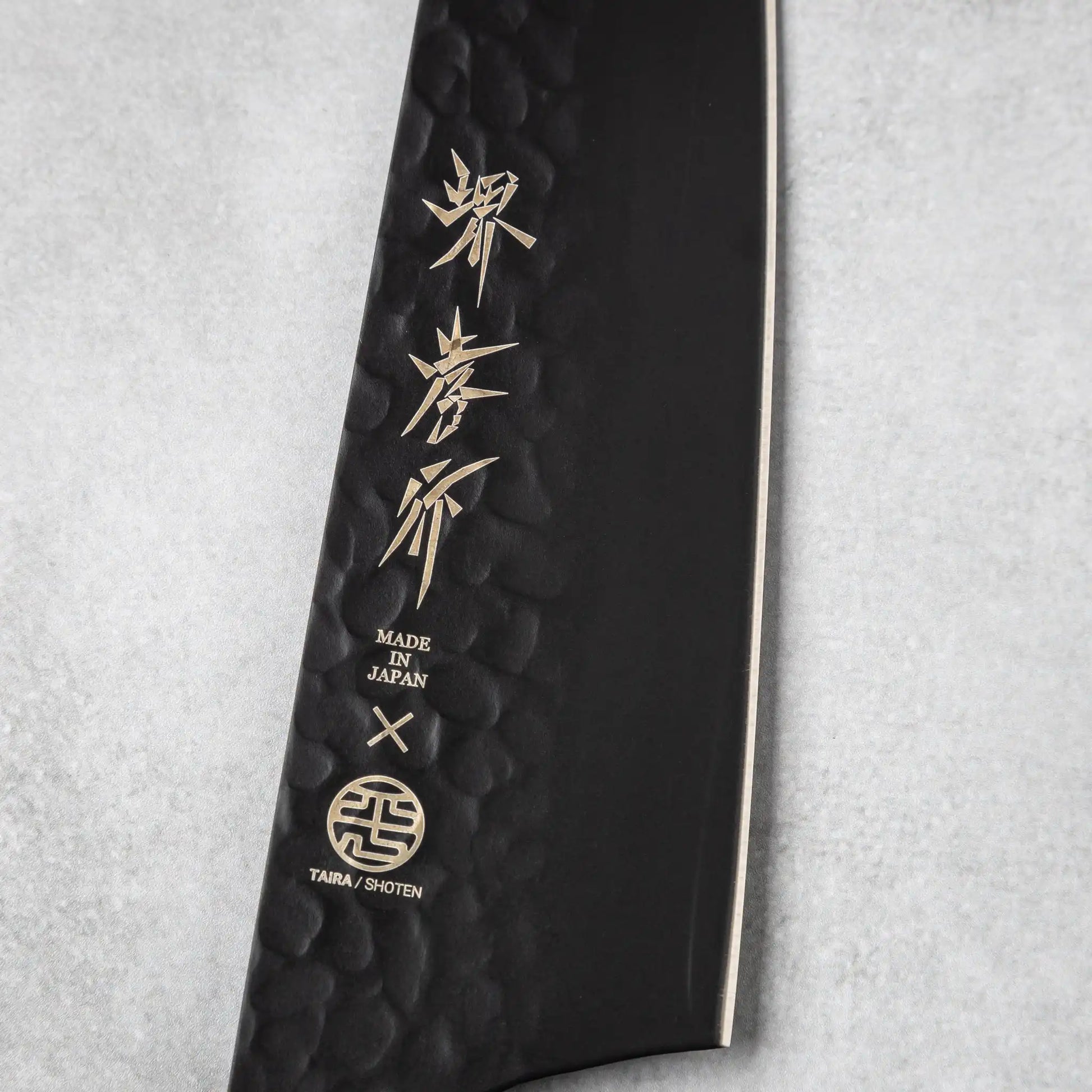 Close-up of the branding and etched details on the blade of the Sakai Takayuki Kurokage VG10 Kengata Santoku Knife, emphasizing its Japanese craftsmanship and quality