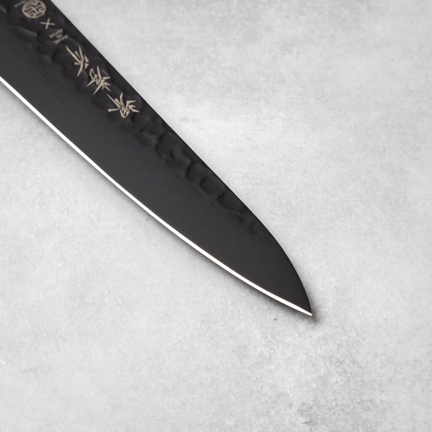 The precise blade tip of the Sakai Takayuki Kurokage VG10 petty knife, emphasizing its sharp edge and detailed craftsmanship.
