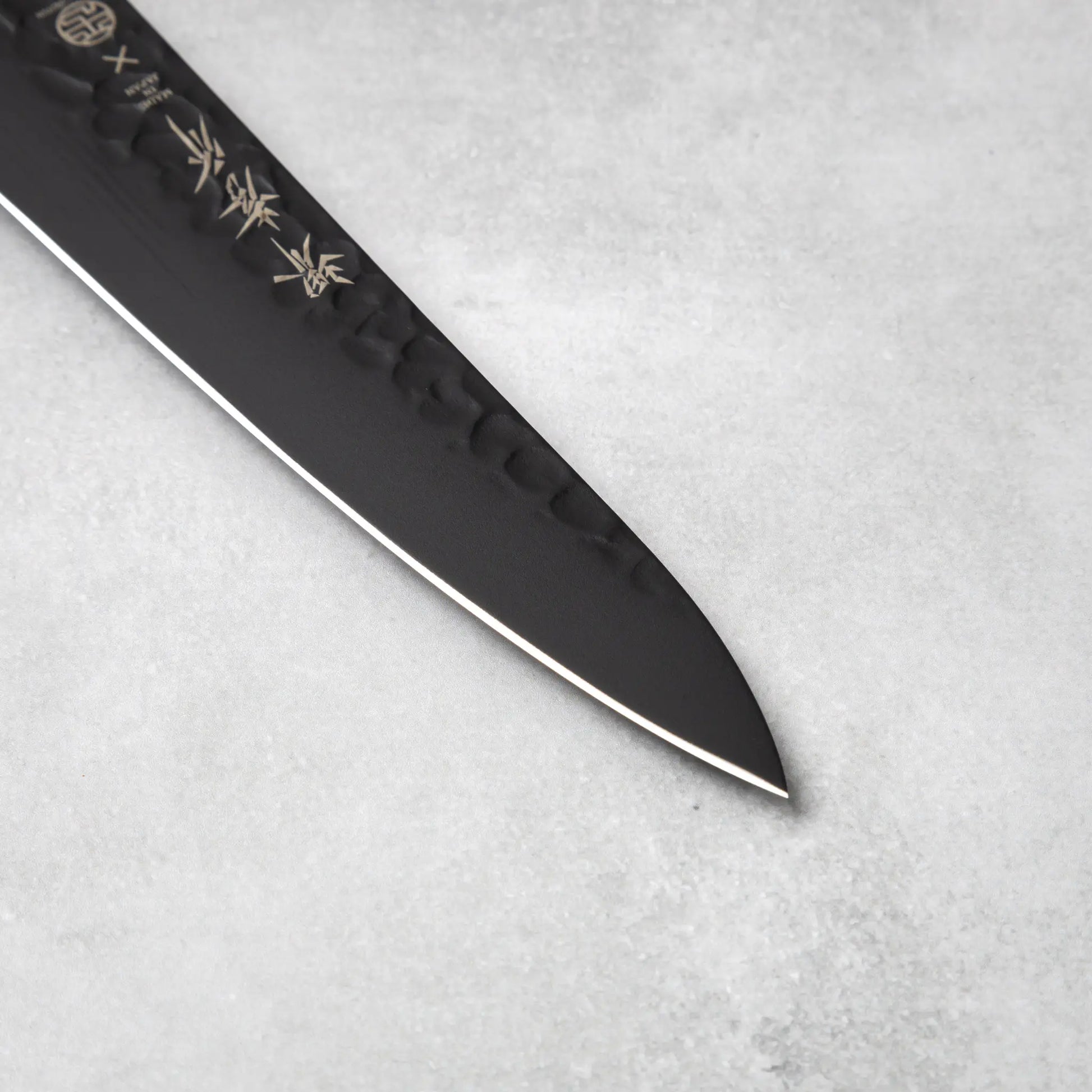 The precise blade tip of the Sakai Takayuki Kurokage VG10 petty knife, emphasizing its sharp edge and detailed craftsmanship.