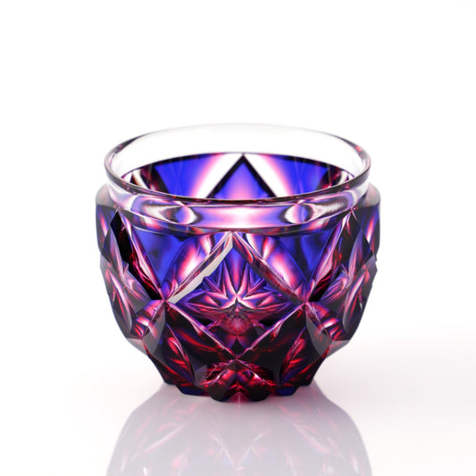 A detailed shot of a Satsuma Kiriko Lapis Red sake cup with diamond-cut facets.