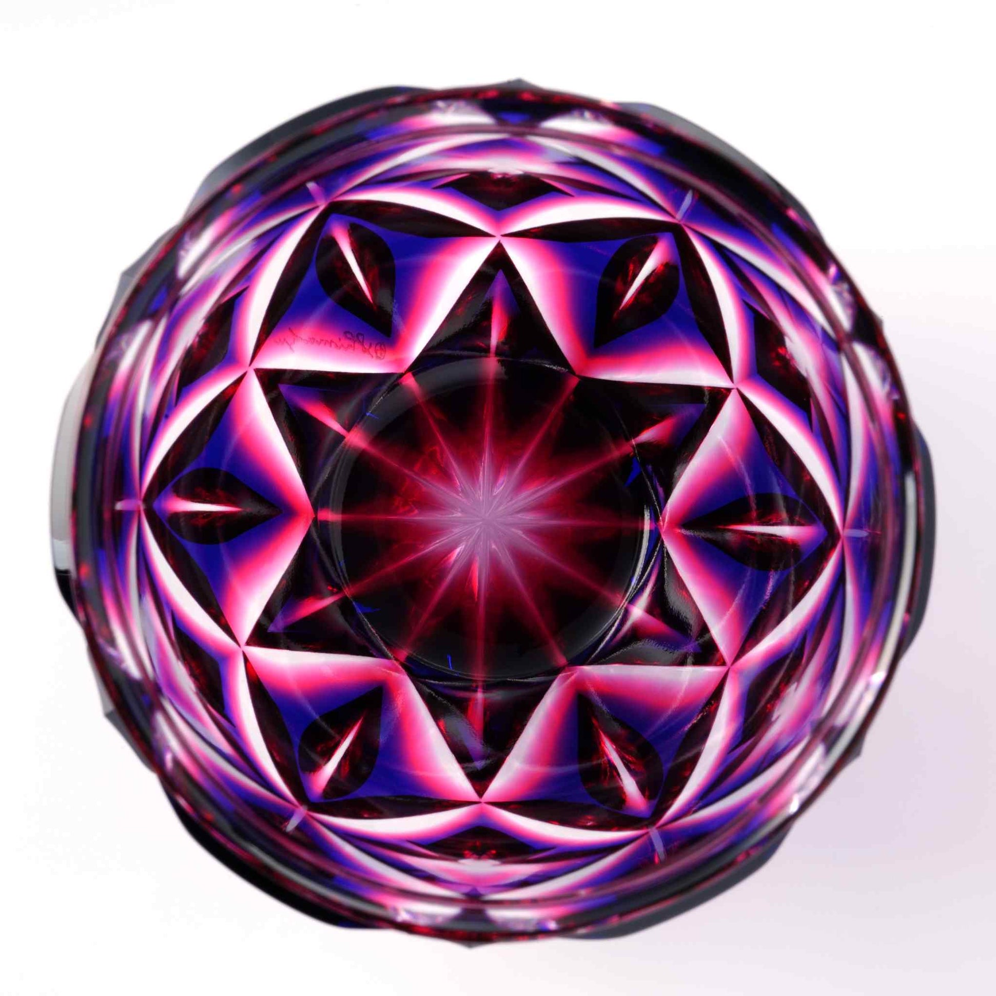 Bottom view of a Satsuma Kiriko Lapis Red sake cup with a star-shaped cut design.
