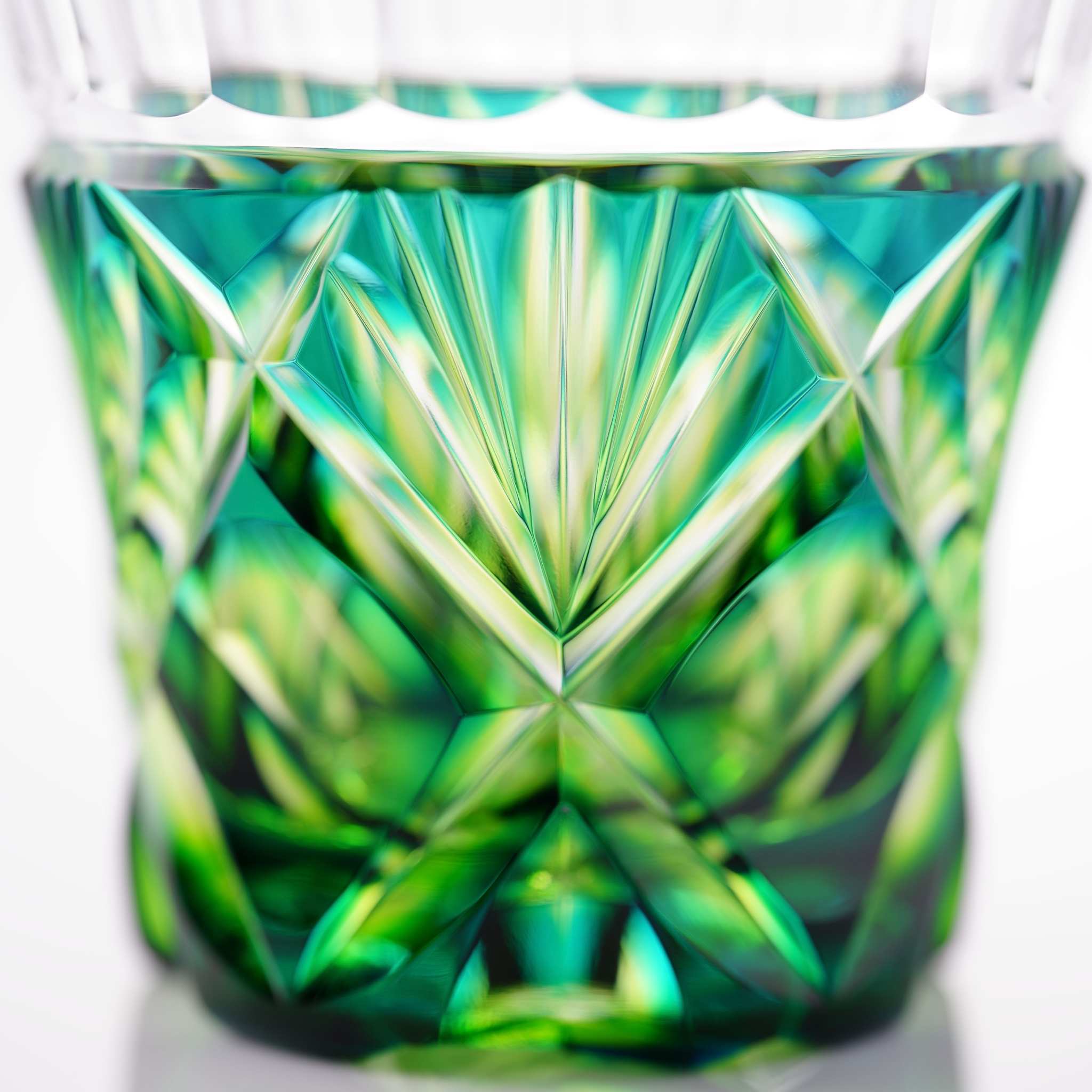 Side view detail of the pattern on Satsuma Kiriko two-tone sake cup in Cyan Yellow Green, highlighting the brilliance.