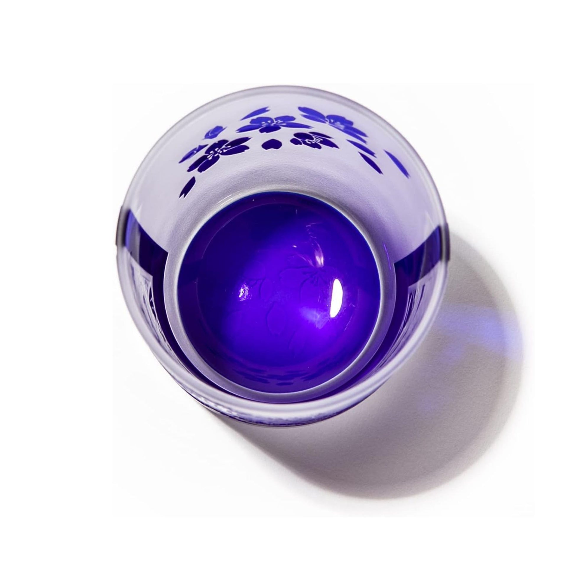 Overhead view of the whiskey glass highlighting the vibrant blue interior and sakura pattern inside the rim