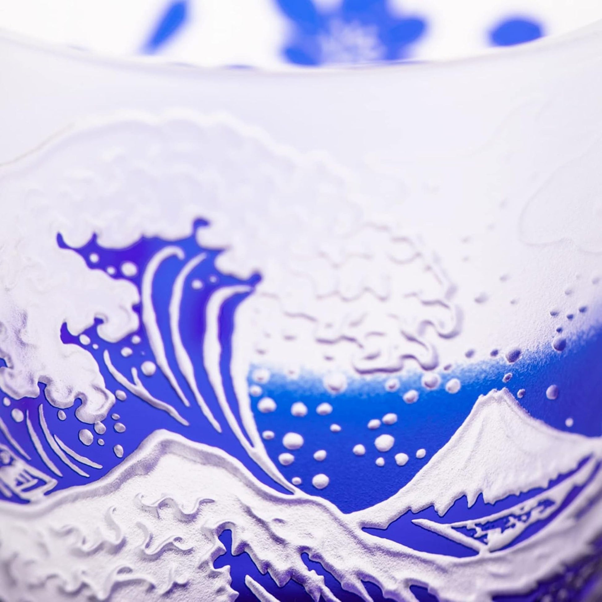 Detailed close-up of the glass's etched wave and Mount Fuji design, displaying the fine craftsmanship and textured surface.