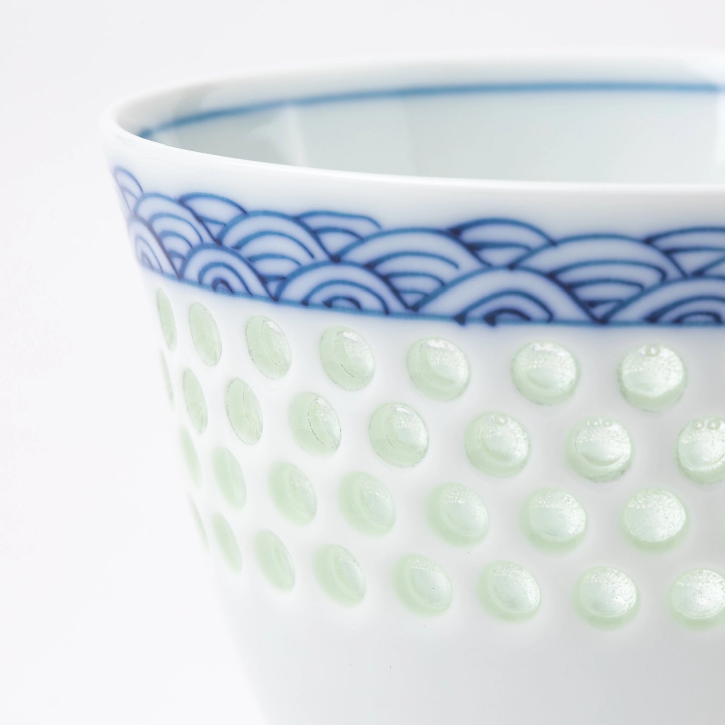 Close-up of the dotted celadon texture and wave motif on the Tanshingama Crest Cup.