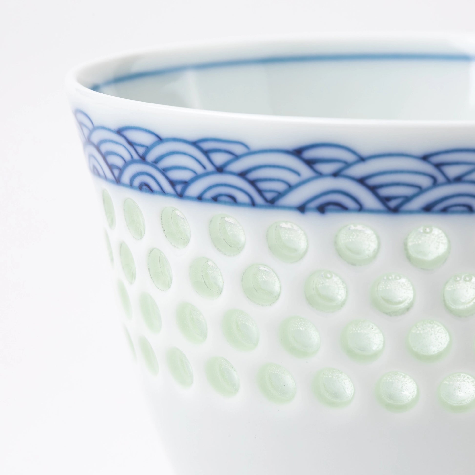 Close-up of the dotted celadon texture and wave motif on the Tanshingama Crest Cup.