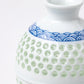 Close-up of the textured celadon glaze and hand-painted wave design on the sake bottle.