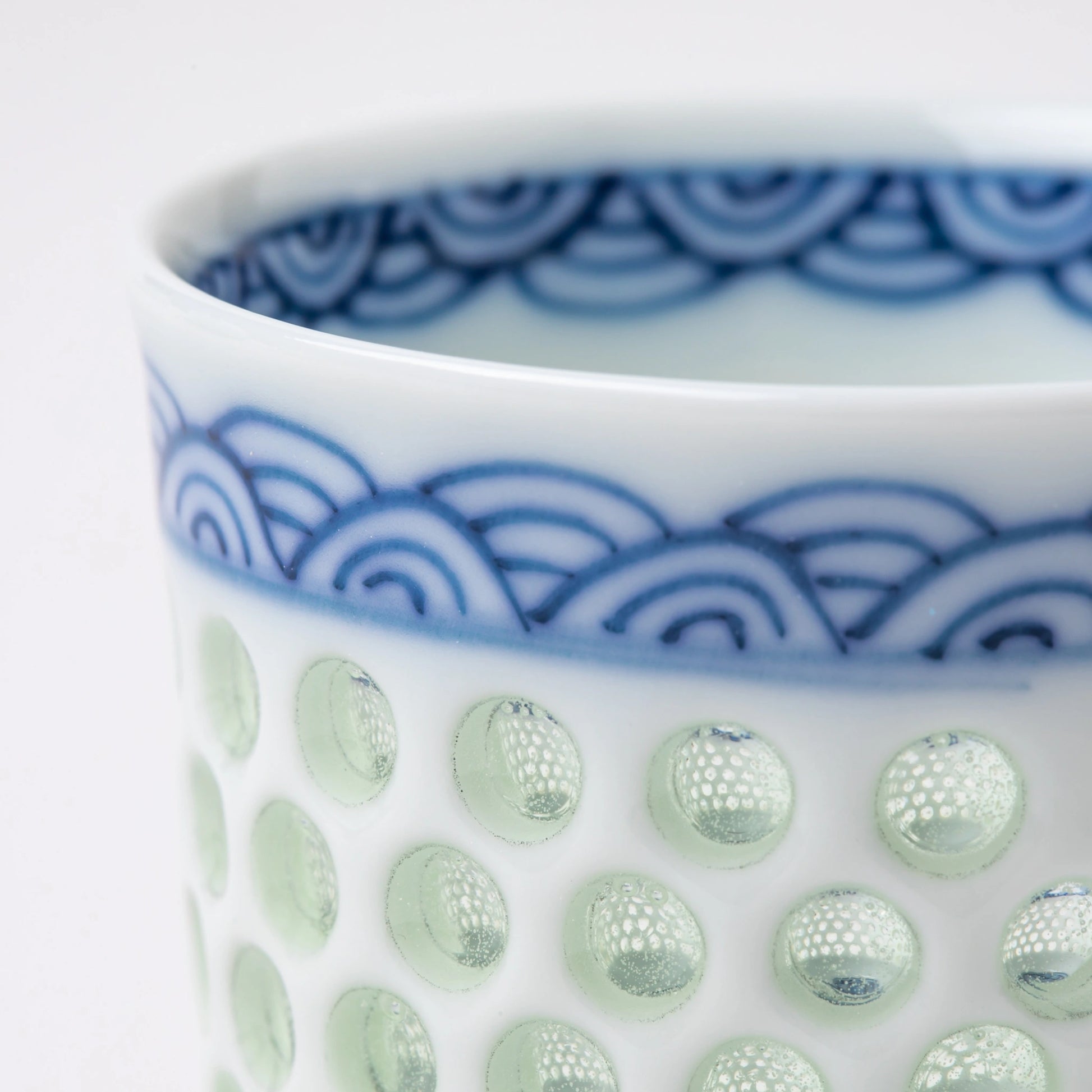 Detail of the Tanshingama Sake Cup showing celadon dot texture and hand-painted wave motif.